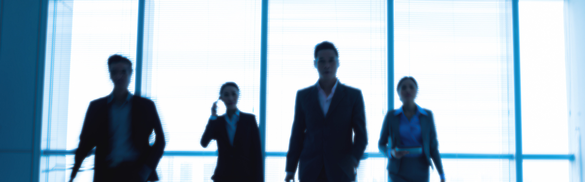 Four people walking in front of window