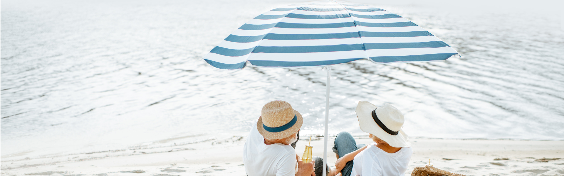 seniors on beach under umbrella