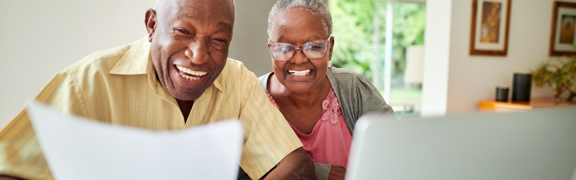 Happy Retirement Couple looking at a document and laptop