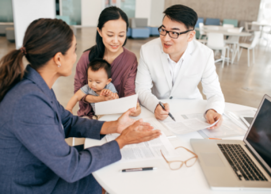 mother and father with baby talking to an agent