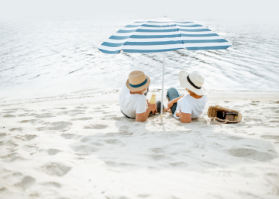 seniors on beach under umbrella