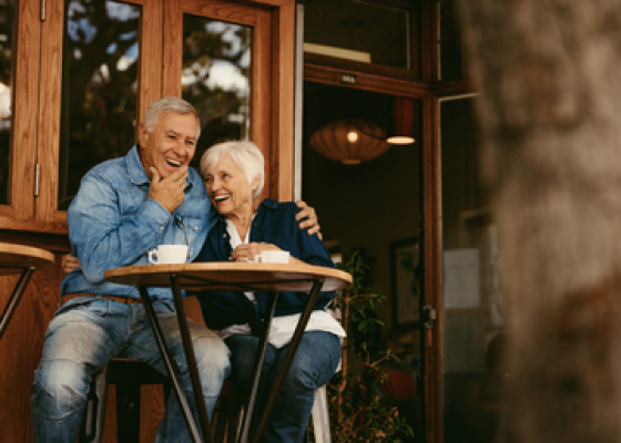 senior couple laughing at coffee table
