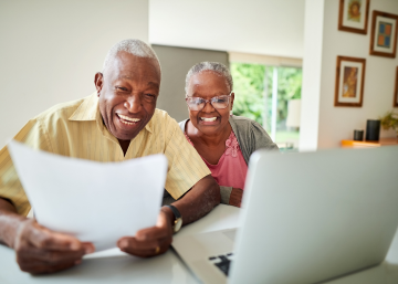 Happy Retired Couple looking at document and computer