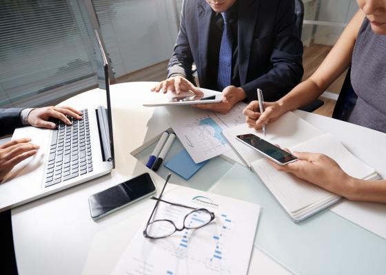 Three people working at a desk in the office