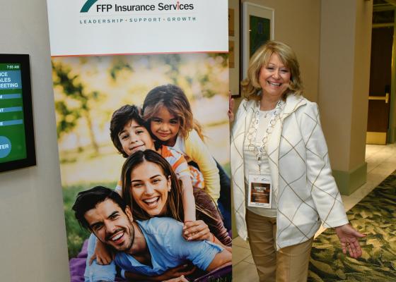 Woman standing infront of banner.